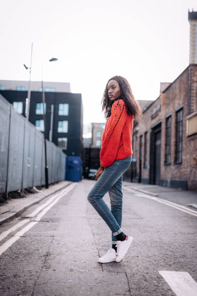 istock Ecstatic Nigerian woman smiling and posing in red sweater 1047711756