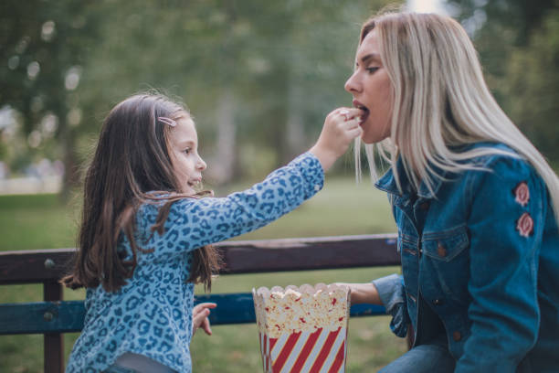istock Mother and child eating popcorn 1047715134