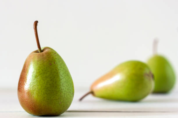 istock Fresh ripe pears lie on a white wooden table 1047718560