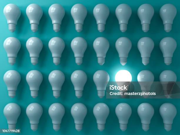 One Glowing Light Bulb Standing Out From The Unlit Or Dim Bulbs On Dark Green Pastel Color Background Individuality And Think Different The Business Creative Idea Concepts 3d Rendering Stock Photo - Download Image Now