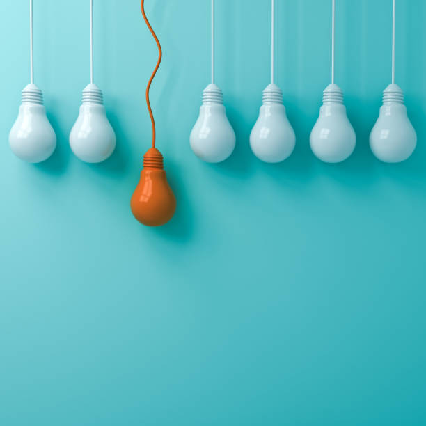 istock Think different concept One hanging orange light bulb standing out from the dim white light bulbs on green pastel color wall background leadership and individuality creative idea concepts 3D rendering 1047719512