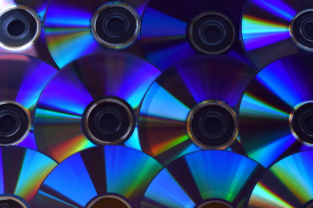 istock Background of illuminated DVD discs and CDs. 1047719516