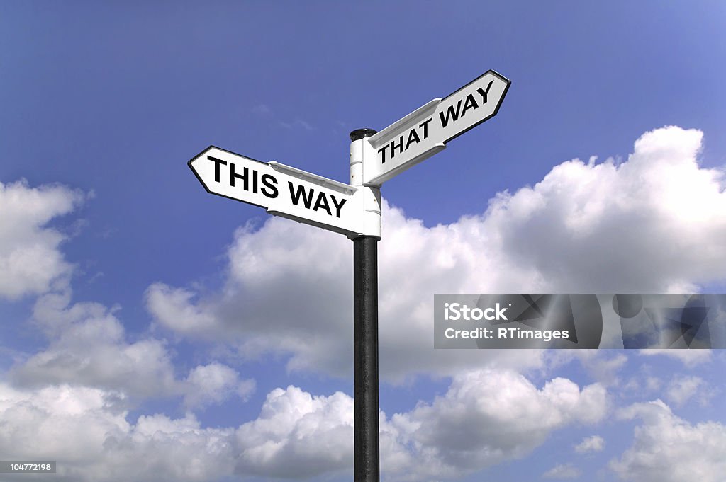 Which way to turn Signpost saying This Way That Way, Which way to turn good concept image for direction related themes.. Directional Sign Stock Photo