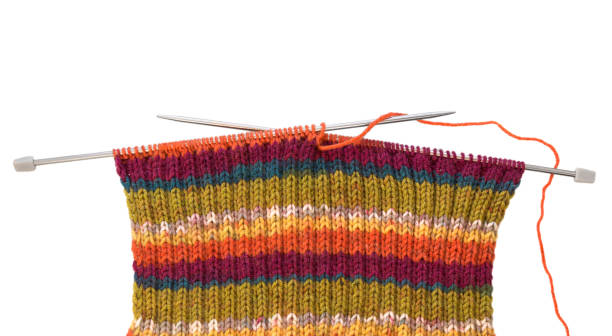 istock Knitting pattern on needles of woolen threads colorful isolated on white 1047724606