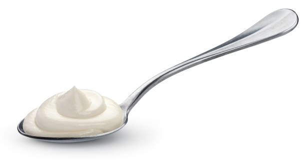 istock Sour cream in spoon isolated on white background 1047724800