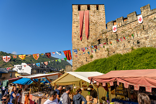 Locals and tourists visit Medieval market next to historic Knights Templar castle during local festivities in Ponferrada, Spain.