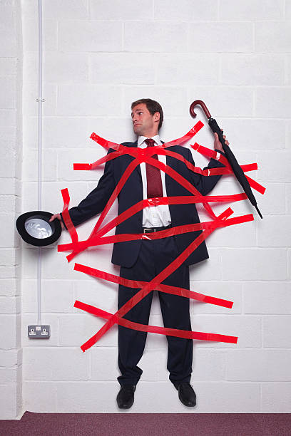 geschäftsmann stuck-wand mit roten band - red tape adhesive tape red bureaucracy stock-fotos und bilder
