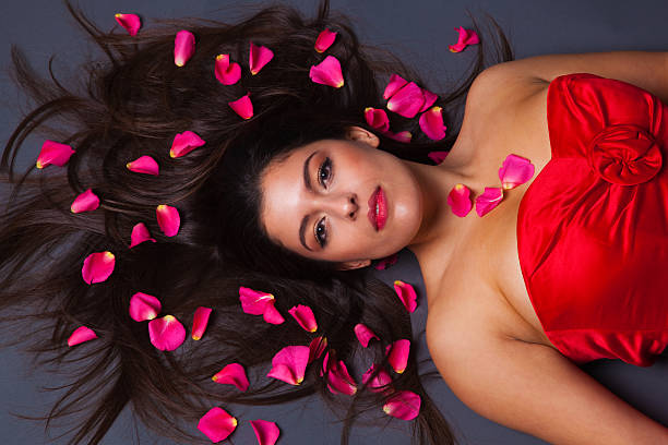 schöne brunette mit rosenblüten auf ihrem haar - human hair women horizontal rose petals stock-fotos und bilder