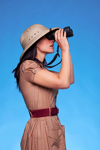 istock Woman in safari hat looking through binoculars side view 104774271