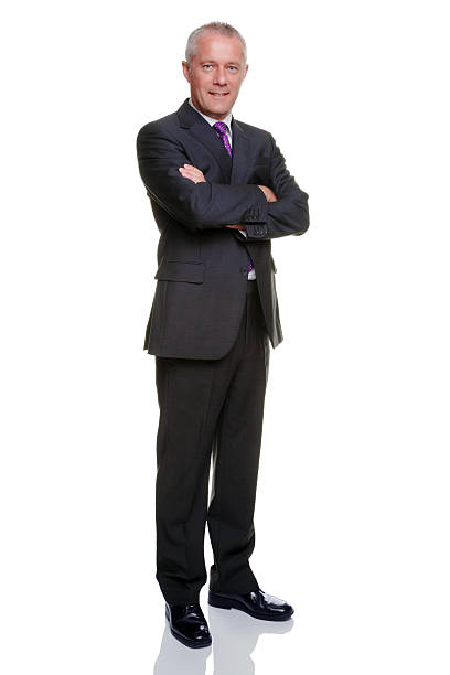 Businessman arms folded Mature businessman in his late 40s standing with arms folded looking to camera, isolated on a white background. man standing profile stock pictures, royalty-free photos & images