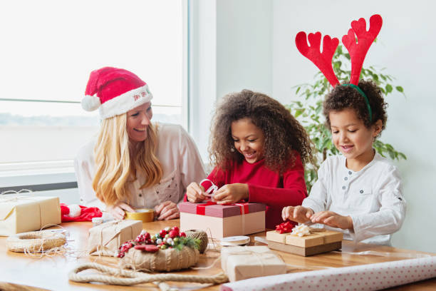 istock Family wrapping Christmas presents at the table 1047744630