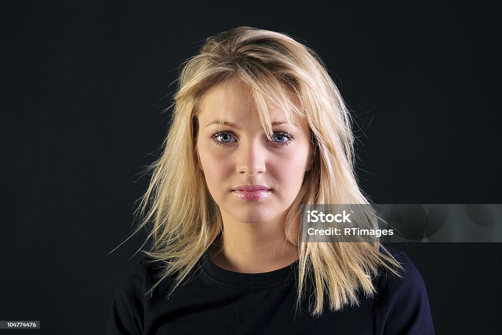 Beautiful blonde portrait Portrait of a beautiful blonde haired woman with blue eyes on a black background. Blond Hair Stock Photo