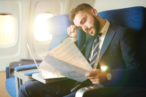 istock Tired Businessman Working in Plane 1047752686