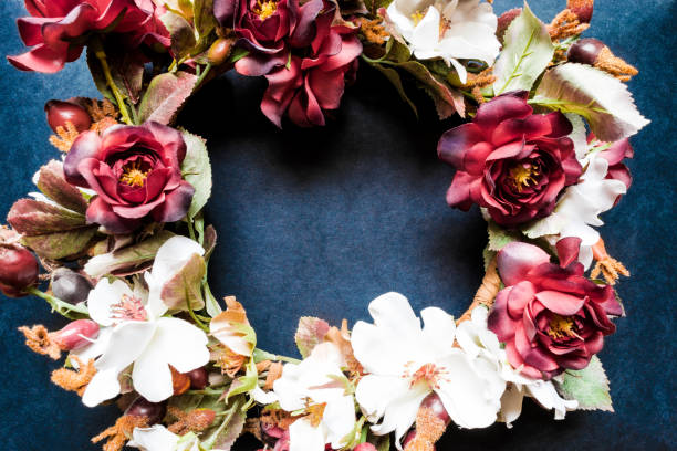 Artificial flowers wreath on blue background surface with free space. Vintage Style