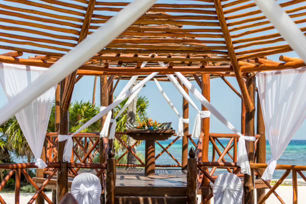 istock Mexican wedding pergola before the ceremony decorated with cloth and ribbons and featuring a bouquet on the alter overlooing the caribbean sea 1047756486