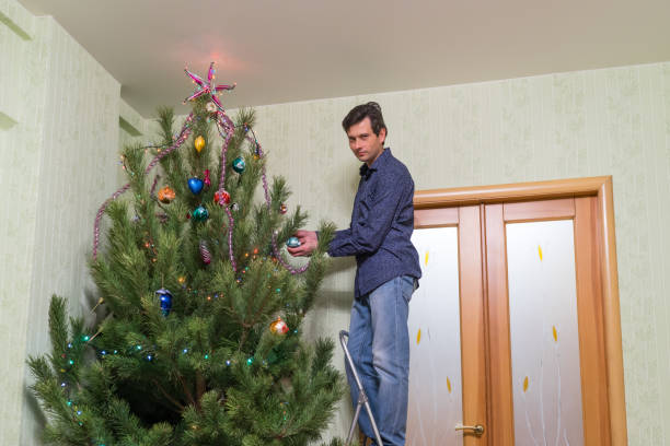 istock Handsome middle-aged man decorates a Christmas tree with new yea 1047757156