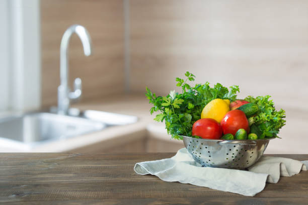 istock Modern kitchen with fresh vegetables on wooden tabletop, space for you and display products. 1047757492