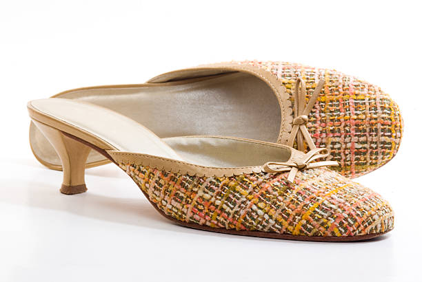 A pair of yellow fabric shoes with heels.
