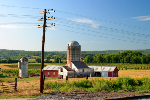 farm with silo under beautiful blue afternoon sky.