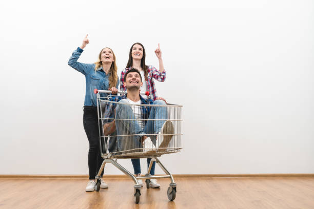 istock The three people with a shopping cart gesture on a white wall background 1047769526