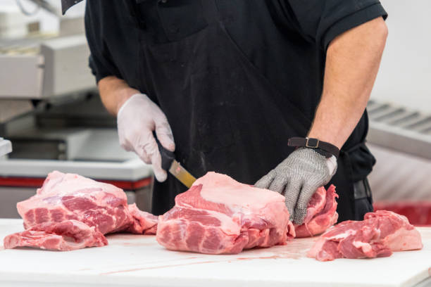 butcher en el trabajo - cortar en trozos preparar comida fotos fotografías e imágenes de stock