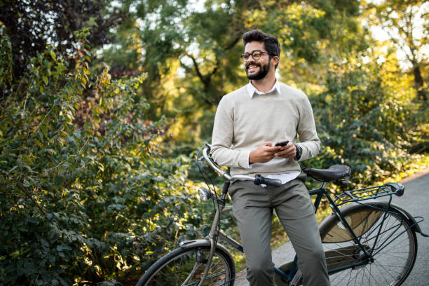 istock cyclist in park checking his smartphone 1047778080