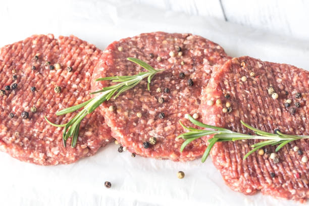 istock Raw beef patties on the white parchment 1047779288