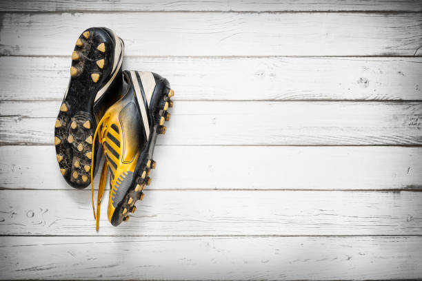 Football shoes hanging on wooden wall Old football shoes hanging on wooden wall football boot stock pictures, royalty-free photos & images