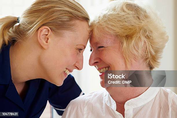 Foto de Retrato De Mulher Sênior E Enfermeira No Abraço Amante e mais fotos de stock de Caseiro