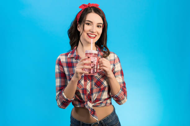 istock The woman with a drink standing on the blue background 1047787130