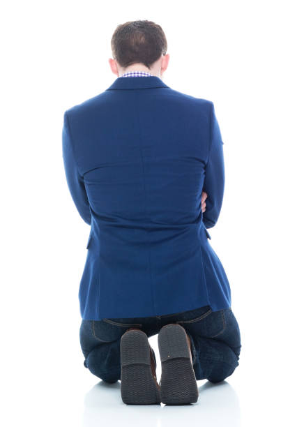 Businessman kneeling Handsome businessman in blue jacket and wearing jeans kneeling stock pictures, royalty-free photos & images