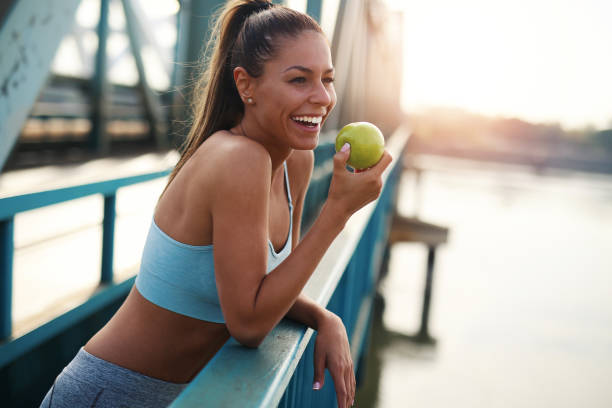 здоровый образ жизни - apple women green eating стоковые фото и изображения