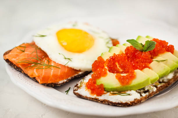 istock Avocado and red caviar, smoked salmon and fried egg rye toasts for breakfast 1047795484