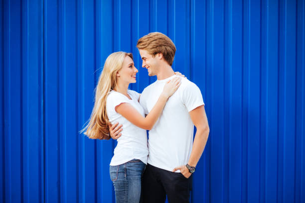 istock young couple smiling on a blue background 1047816524