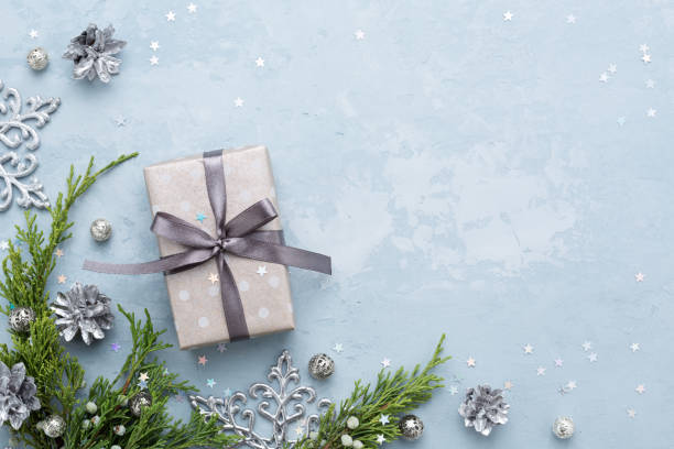 Christmas composition with evergreen branches and gift on blue space.