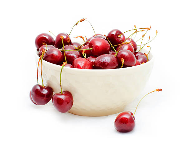 sweet cherries in a white bowl isolated stock photo