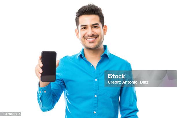 Attractive Male Smiling While Holding Smartphone Stock Photo - Download Image Now - Men, Mobile Phone, Telephone