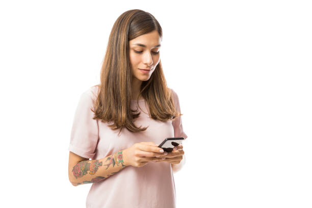 istock Beautiful Young Woman Checking Emails On Mobile Phone 1047848768