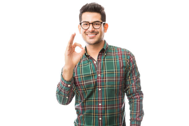 istock Fashionable Male Showing Ok Gesture Over Plain Background 1047849118