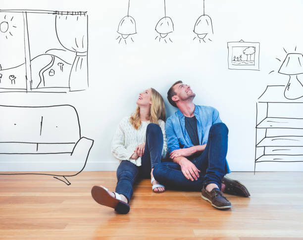 Couple dreaming of their new house. Couple dreaming of their new house. They are sitting on a wooden floor imagining their new home with furniture in it. The house is currently empty. They are booth looking up and smiling happily. pencil drawing photos stock pictures, royalty-free photos & images