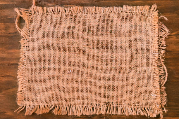 istock A piece of linen fabric in the shape of a rectangle on a wooden background. 1047856492