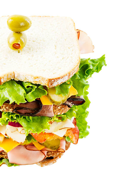 Dagwood Sandwich High angle view of a large, multi-layered sandwich with pimento olives on top; copy space to right dagwood stock pictures, royalty-free photos & images