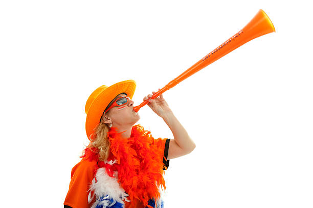 Dutch soccer supprter with plastic vuvuzela Female Dutch soccer supporter with orange plastic vuvuzela over white background vuvuzela stock pictures, royalty-free photos & images