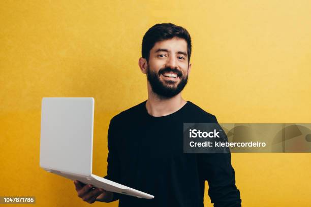 Young Man With Laptop On Color Background Studio Portrait Stock Photo - Download Image Now