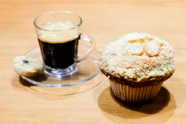 istock cup of espresso with cupcake on wooden table 1047871890