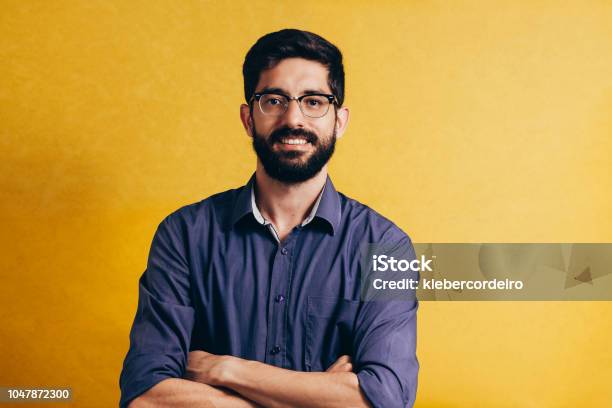 Portrait Of A Smiling Bearded Man In Eyeglasses Looking At Camera Isolated Over Yellow Background Stock Photo - Download Image Now