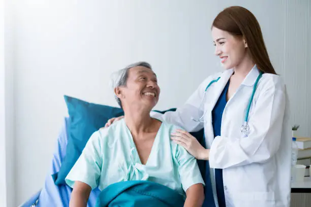 attractive asian woman nurse and doctor working with smiling and freshness together to takecare ill old senior patient in hospital