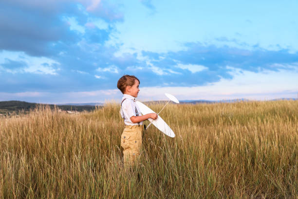 istock Happy boy play with little white plane. 1047876592