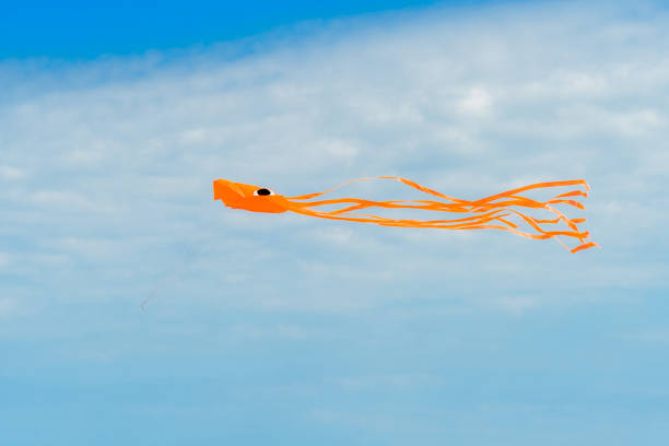 istock Orange Kite Flying in the Sky 1047897962