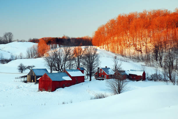 Woodstock, VT, USA December 17, 2009 The sun rises for a snowy beginning of the day on a farm near Woodstock, Vermont